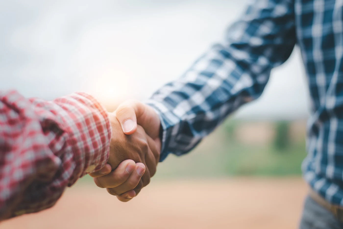 Close-up of two people shaking hands outdoors, symbolizing trust, partnership, and commitment – reflecting the strong collaboration between Window King and ProVia to protect customers’ investments.