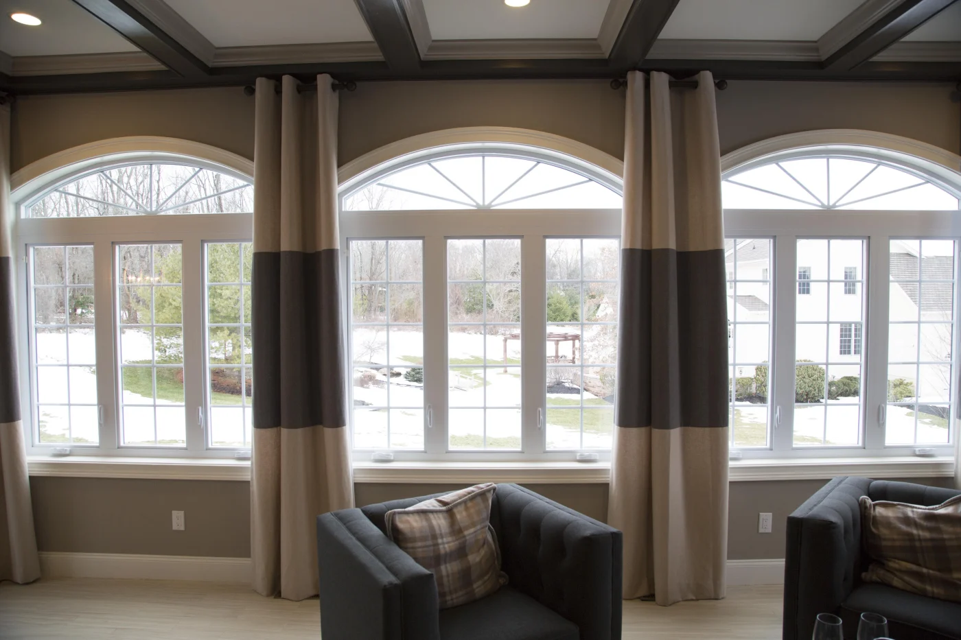 A stunning set of Starmark Evo composite windows in a wide living room bay, framed by elegant arched transoms. The deep, rich window profiles offer the look of premium wood while delivering advanced performance and low-maintenance durability. Crafted by the same brilliant minds behind OKNA, Starmark Evo delivers beauty and resilience built for NY Metro living.