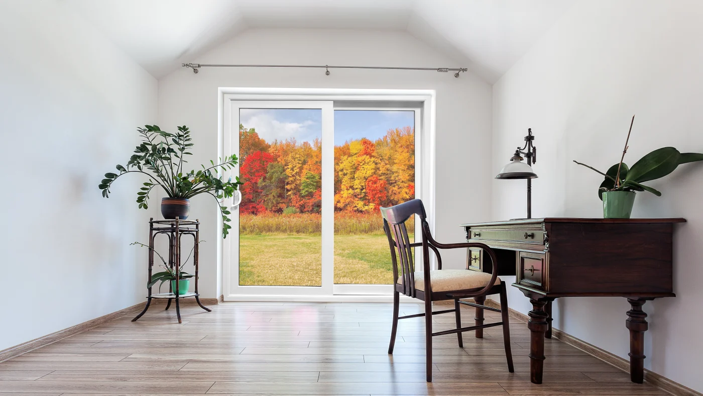 The OKNA patio door appears flawless—sharp lines, pristine white frame, and spotless glass – while the autumn foliage outside looks almost hyper-saturated, with no glare, distortion, or depth haze that you’d usually get shooting through glass. The indoor scene also feels deliberately styled, with perfect lighting, balanced shadows, and no lived-in details.