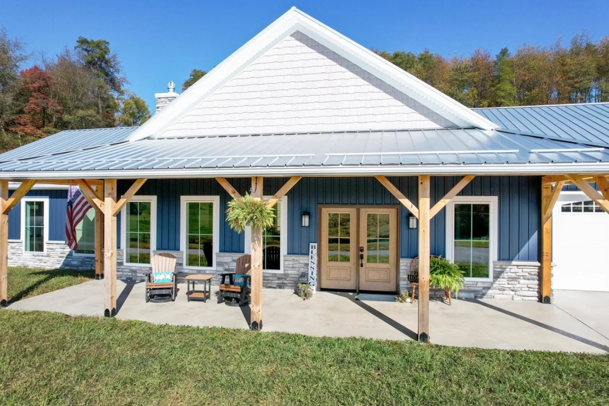 A double ProVia Signet Oak front entry door stained in Almond, set against a blue board-and-batten exterior with stone accents under a covered porch.