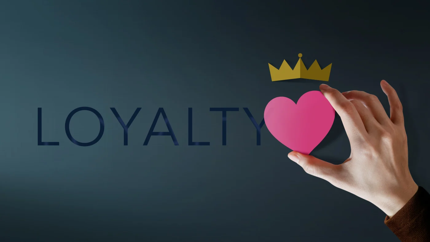 Three Kinds Of Loyalty | One Standard Of Customer Care | Window King A hand holds a pink heart against a dark background, with the word “LOYALTY” in bold letters behind it. Above the heart rests a small golden crown, symbolizing Window King’s family values of loyalty, care, and royal treatment for every customer.