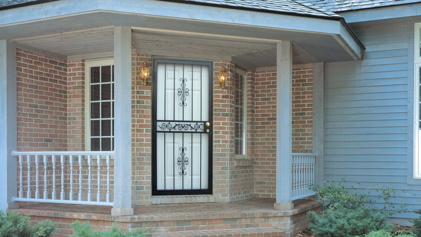 A close-up of a beautifully installed HomeGuard security storm door framed by detailed brickwork and flanked by classic lantern-style lights. The installation is clean, symmetrical, and secure—reflecting Window King’s depth of experience across thousands of projects. Every line, angle, and finish says: this was done by seasoned pros who know exactly what they’re doing.