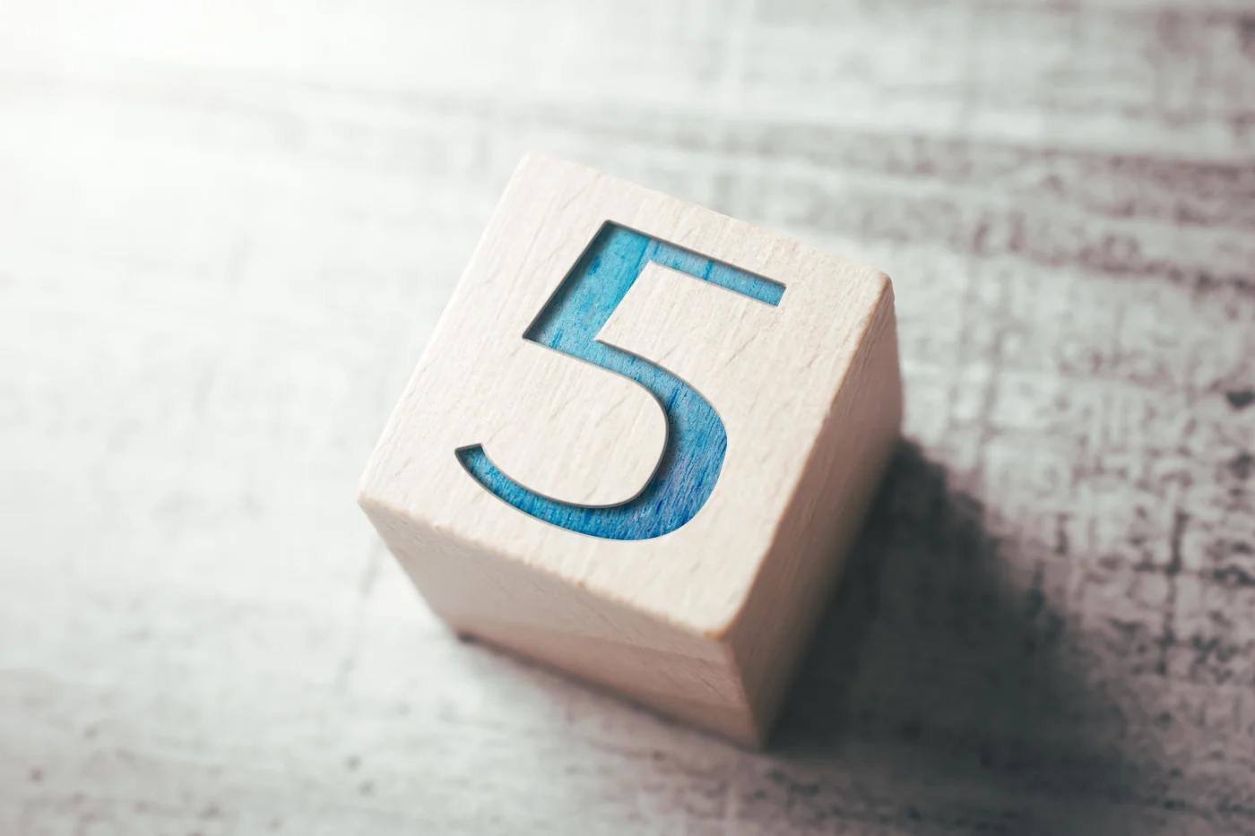 Five Core Values | Five Promises & Commitments | Window King A close-up of a wooden block etched with the number five, symbolizing Window King’s five core values and the promises they make on every window and door project.