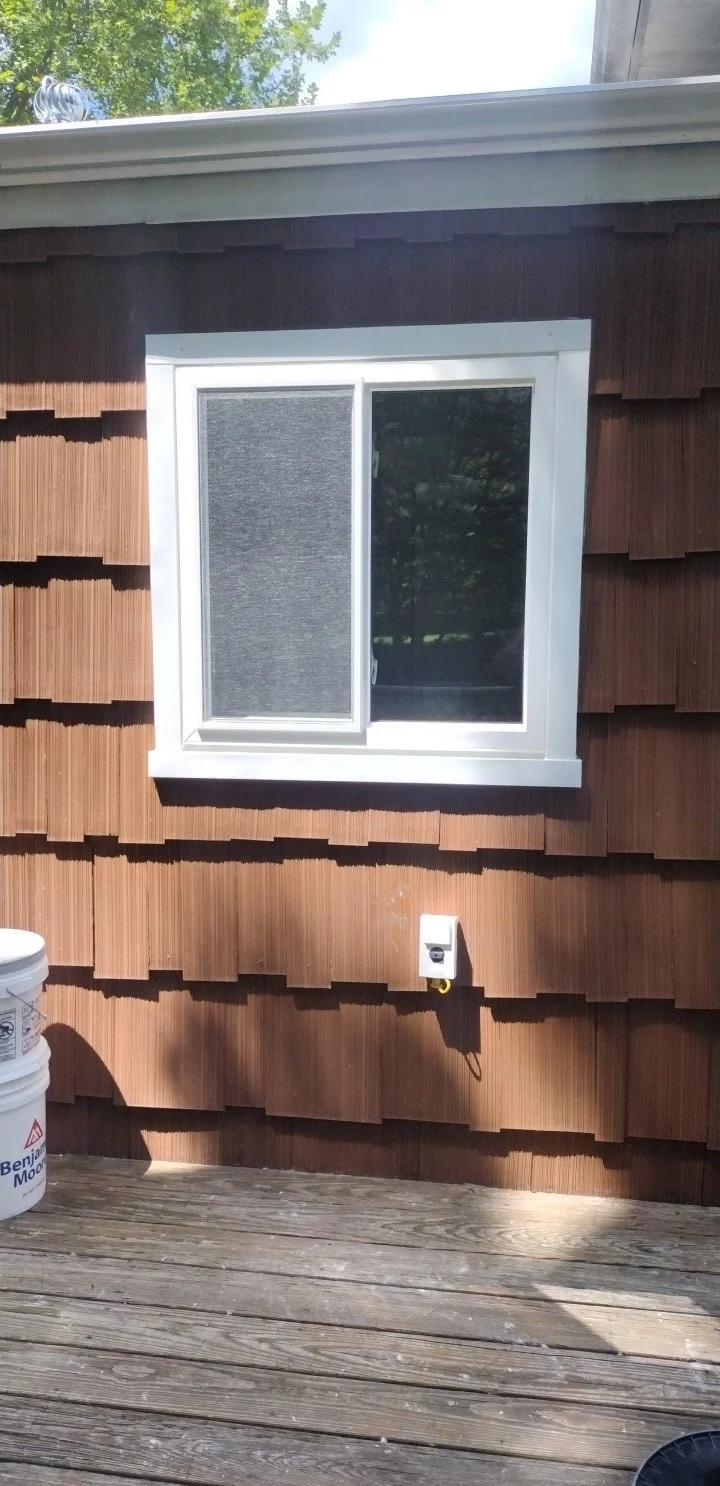 Custom sliding replacement window installed in a shingle-style home exterior, showcasing clean white trim and energy-efficient window design.