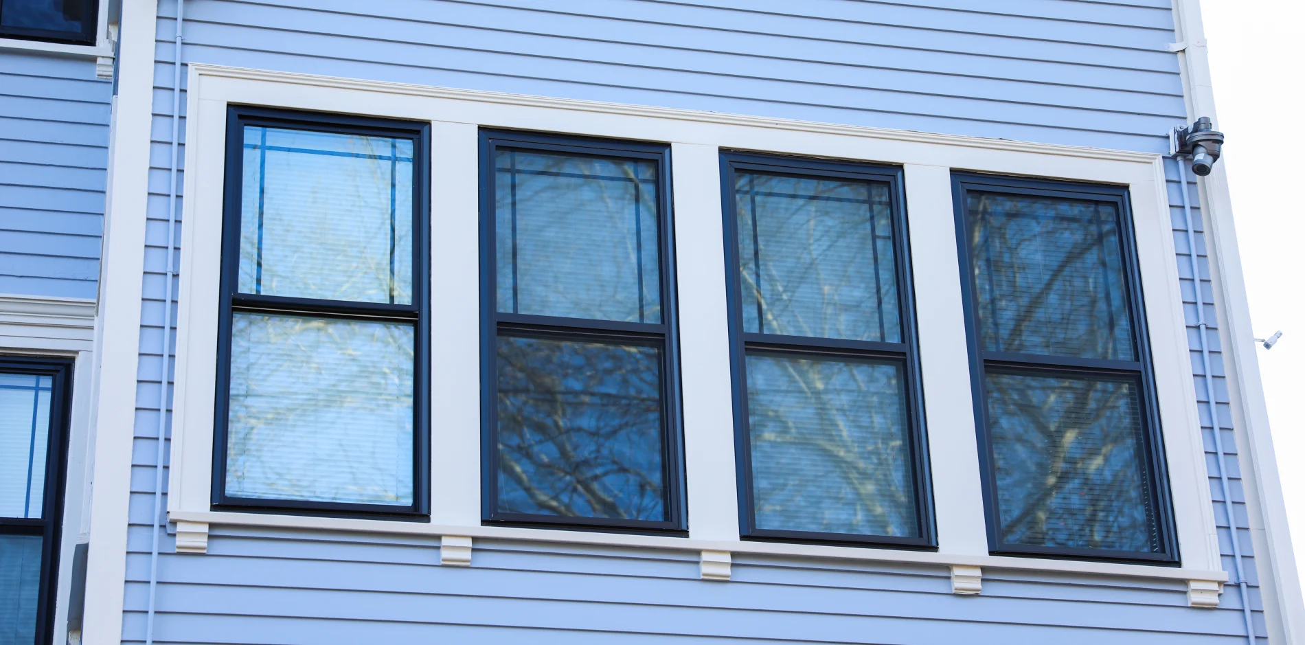 Custom sliding replacement window installed in a shingle-style home exterior, showcasing clean white trim and energy-efficient window design.