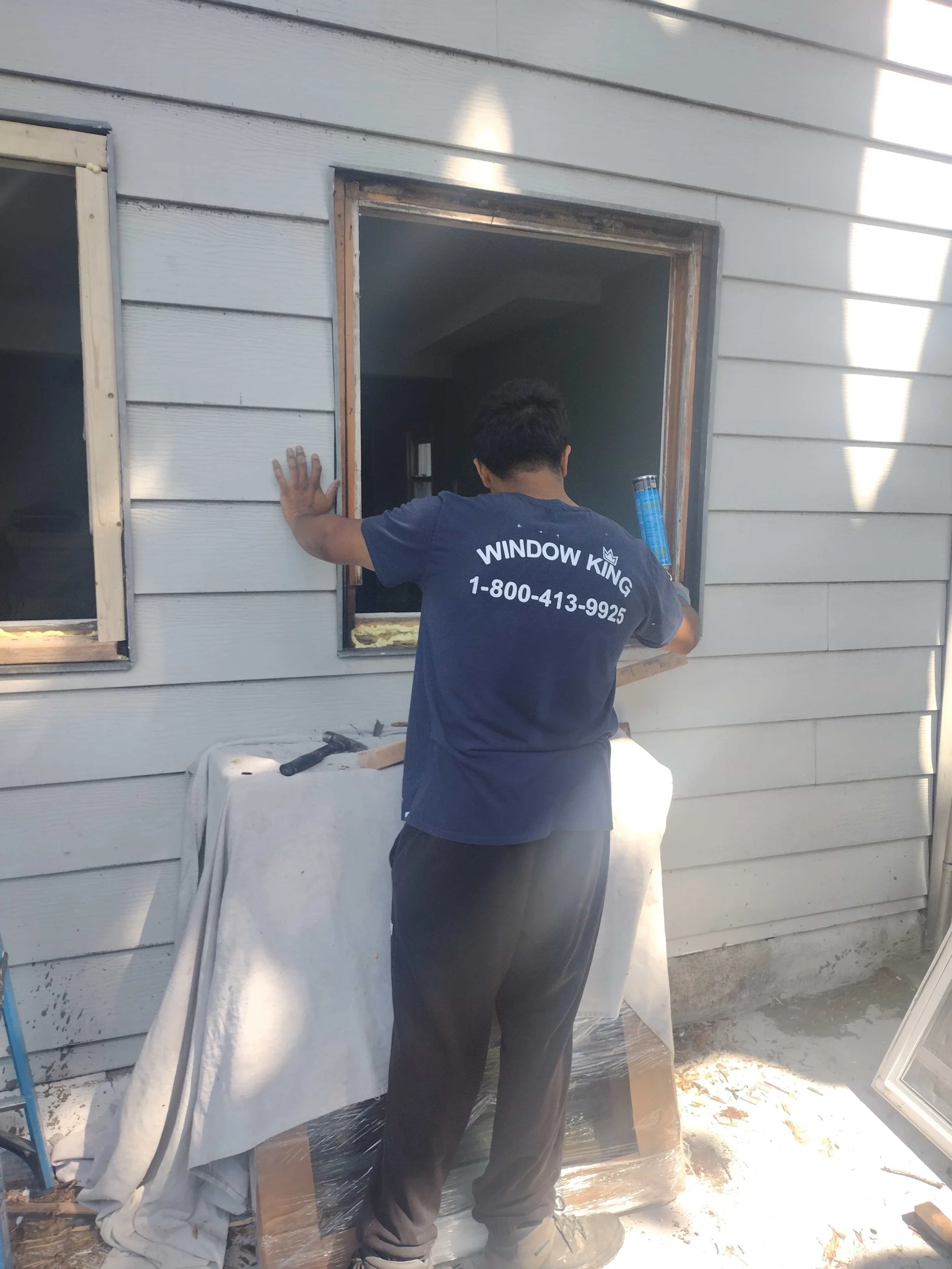 Window Installation Process In New Rochelle, NY - Window King Window King installer applying spray foam insulation during a replacement window installation.
